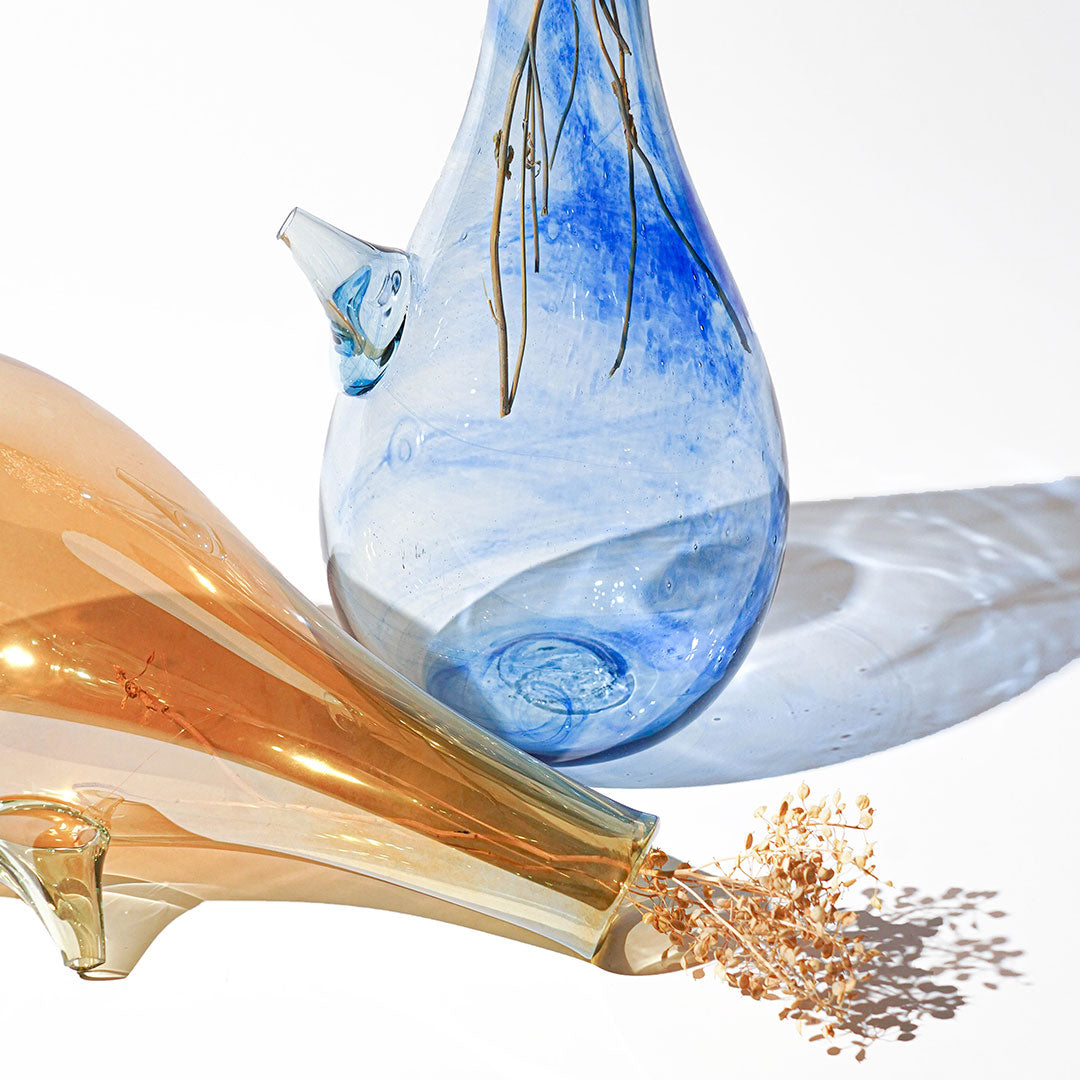 Introducing the Ibrik Recycled Glass Vase and functional liquid Jug – a versatile and eco-friendly piece that seamlessly merges functionality with aesthetic appeal. Crafted with care from recycled glass, the Ibrik is not only a sustainable choice but also a testament to the beauty of repurposed materials.
