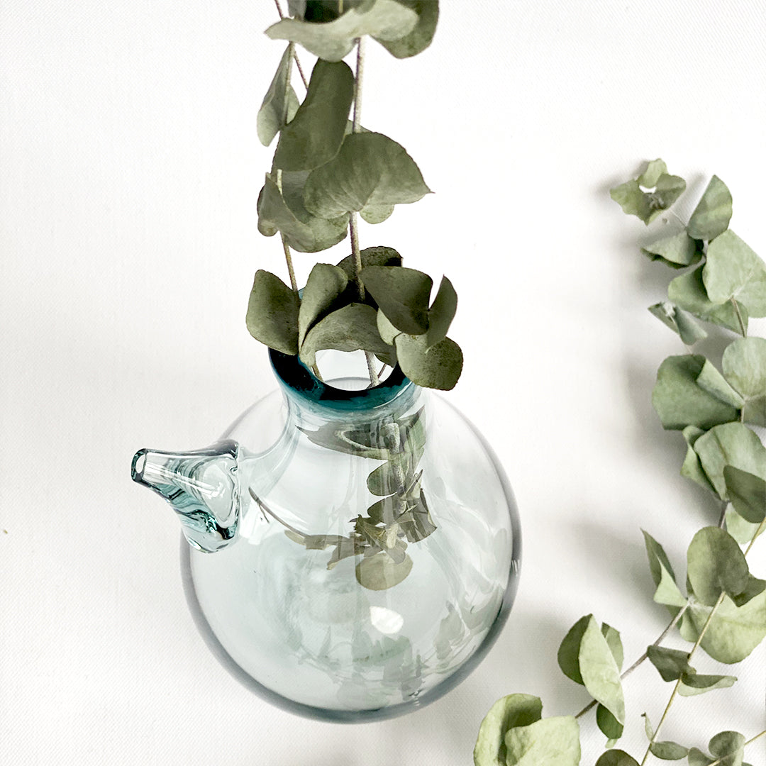 Introducing the Ibrik Recycled Glass Vase and functional liquid Jug – a versatile and eco-friendly piece that seamlessly merges functionality with aesthetic appeal. Crafted with care from recycled glass, the Ibrik is not only a sustainable choice but also a testament to the beauty of repurposed materials.