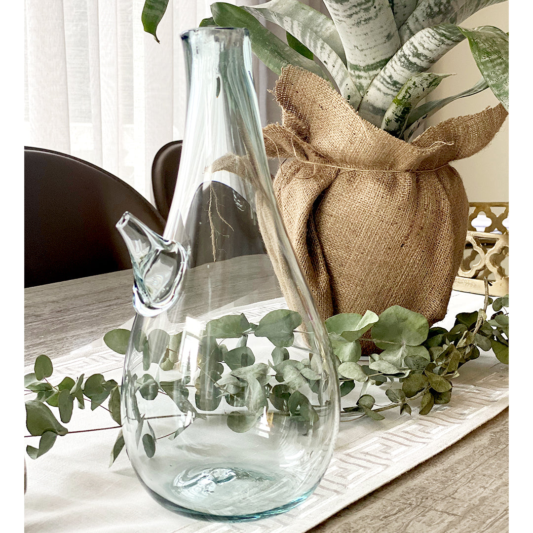 Introducing the Ibrik Recycled Glass Vase and functional liquid Jug – a versatile and eco-friendly piece that seamlessly merges functionality with aesthetic appeal. Crafted with care from recycled glass, the Ibrik is not only a sustainable choice but also a testament to the beauty of repurposed materials.