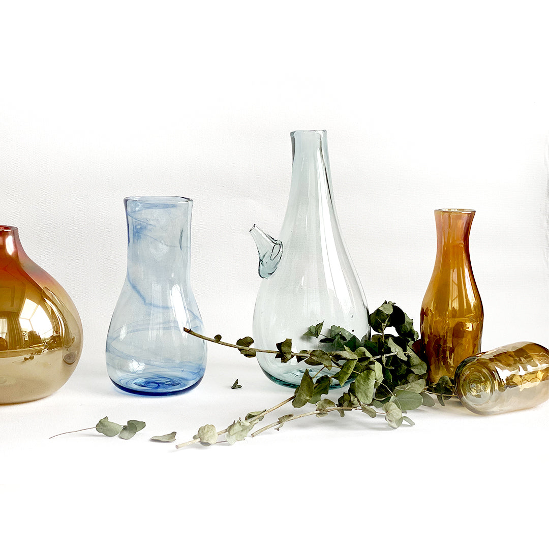 Introducing the Ibrik Recycled Glass Vase and functional liquid Jug – a versatile and eco-friendly piece that seamlessly merges functionality with aesthetic appeal. Crafted with care from recycled glass, the Ibrik is not only a sustainable choice but also a testament to the beauty of repurposed materials.