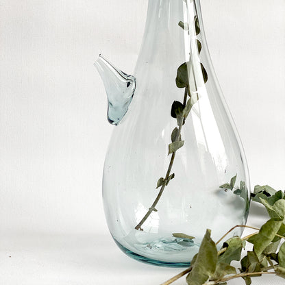 Introducing the Ibrik Recycled Glass Vase and functional liquid Jug – a versatile and eco-friendly piece that seamlessly merges functionality with aesthetic appeal. Crafted with care from recycled glass, the Ibrik is not only a sustainable choice but also a testament to the beauty of repurposed materials.