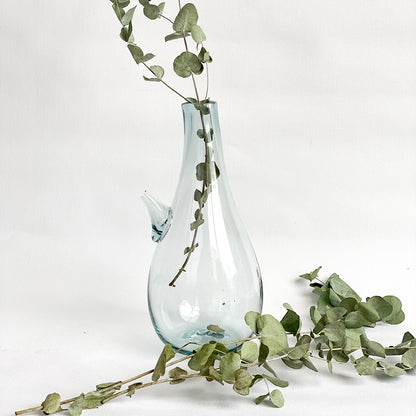 Introducing the Ibrik Recycled Glass Vase and functional liquid Jug – a versatile and eco-friendly piece that seamlessly merges functionality with aesthetic appeal. Crafted with care from recycled glass, the Ibrik is not only a sustainable choice but also a testament to the beauty of repurposed materials.